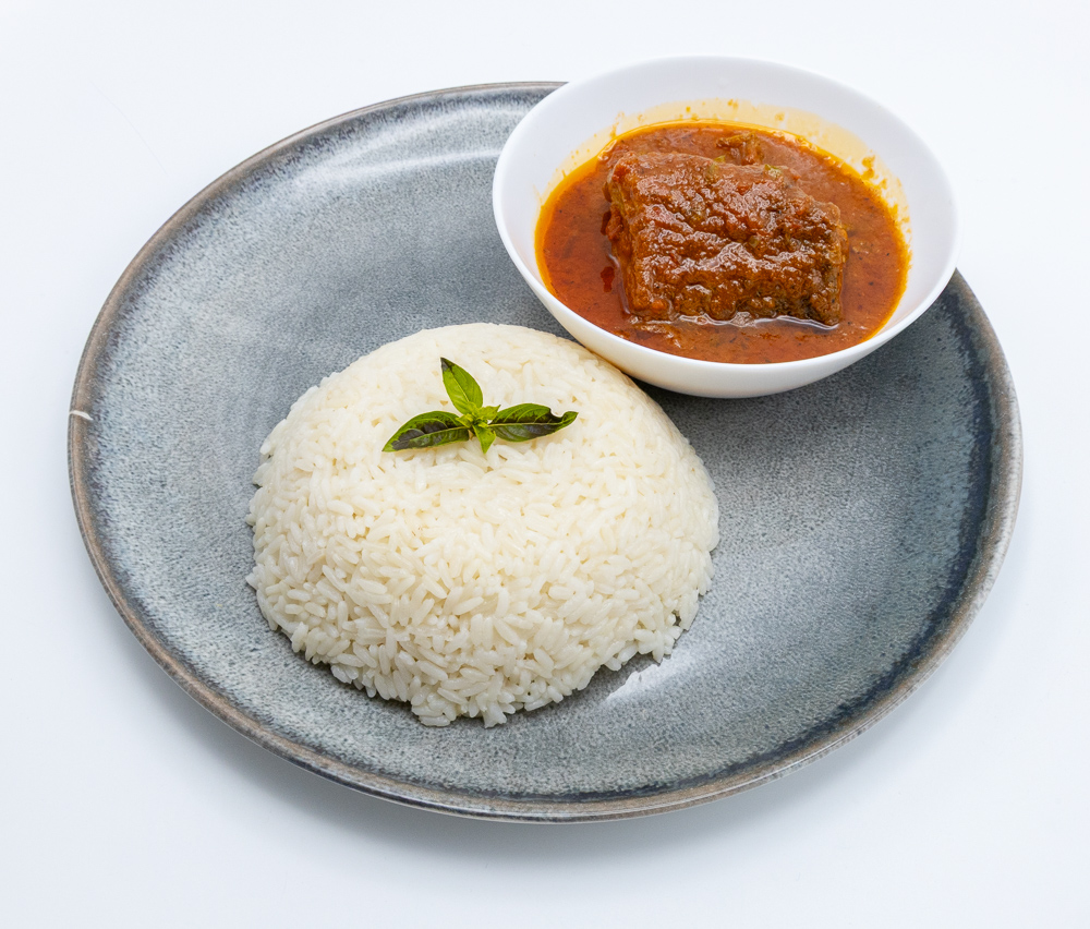 African Rice with a dish of tomato sauce with either fish or beef.